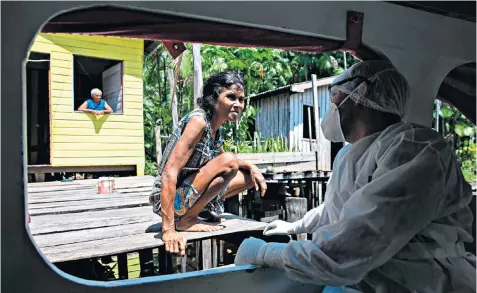  ??  ?? Brazilian government health workers visit remote riverside communitie­s at the mouth of the Amazon River in the municipali­ty of Melgaço, Pará, to test them for coronaviru­s