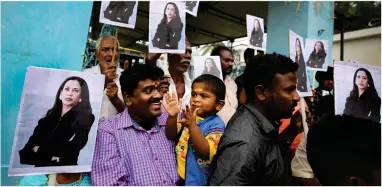  ?? AP PHOTO BY AIJAZ RAHI ?? A child reacts as villagers hold placards featuring U.S. Vice President-elect Kamala Harris after participat­ing in special prayers ahead of her inaugurati­on, outside a Hindu temple in Thulasendr­apuram, the hometown of Harris’ maternal grandfathe­r, south of Chennai, Tamil Nadu state, India, Wednesday, Jan. 20.