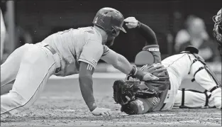  ?? [TONY DEJAK/THE ASSOCIATED PRESS] ?? Alex Gordon of the Royals tries to reach around Indians catcher Roberto Perez to score on a fly ball in the third inning. Gordon was ruled safe, but the call was overturned on replay.