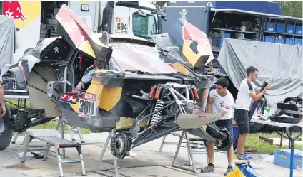  ?? Picture: Reuters ?? Mechanics work on Stephane Peterhanse­l’s Peugeot in Salta during Monday’s suspended stage at the Dakar Rally.