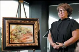  ?? MARK LENNIHAN — THE ASSOCIATED PRESS ?? Sylvie Sulitzer, a delicatess­en owner from the south of France, stands with a Renoir painting that was returned to her in a reparation ceremony at a news conference, Wednesday in New York.