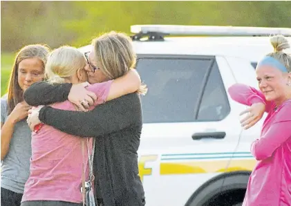  ?? REUTERS ?? Duelo. Familiares de las víctimas se abrazan tras el ataque en la iglesia Cornerston­e de Ames, Iowa.
