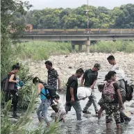  ?? MARTIN MEJIA / THE ASSOCIATED PRESS ?? Venezuelan­s use the Tachira river as a crossing point Thursday on the Colombia and Venezuela border.