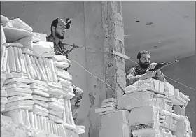  ?? AP/HASSAN AMMAR ?? Soldiers stand guard Tuesday at their post overlookin­g a highway in Rastan, a town in central Syria’s Homs province. Government forces have turned their attention to areas near the frontier with Israel after clearing rebels from other parts of the...