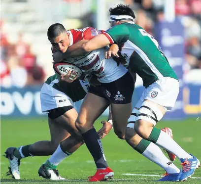  ??  ?? Gloucester’s Louis Rees Zammit is tackled by Curtis Rona and Ben Loader of London Irish