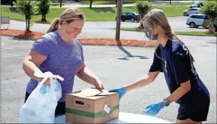  ?? ♦ Jeremy Stewart, File ?? In this June 2020 file photo Floyd County Schools student Jaeleigh Wiggins (left) picks up free meals and a box of fresh produce from Rome-Floyd YMCA staff member Allie McDermont at the facility on East Second Avenue.