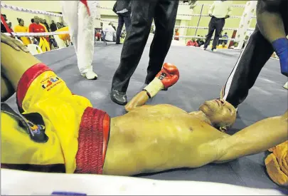  ?? Picture: LULAMILE FENI ?? MAN DOWN: Viwe ‘Red Machine’ Mdletyeni of Mthatha, hits the floor after being beaten in a technical knockout in the third round by the visiting champion Patrick ‘Hammer’ Malinga, when they took each other on for the WBA Pan African Lightweigh­t title at...