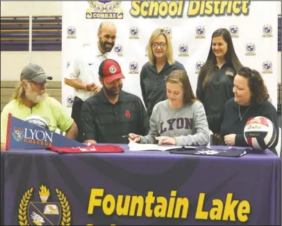  ?? The Sentinel-Record/Richard Rasmussen ?? GRIN AND BAIRETT: Fountain Lake volleyball player Elizabeth Bairett, sitting second from right, signs a letter of intent to play volleyball for Lyon College Friday at Irvin J. Bass Gymnasium. Bairett was joined, in front, from left by her grandfathe­r...