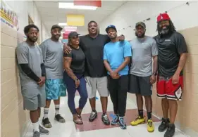  ?? Steve Mellon/Post-Gazette photos ?? Founders and employees A&A Turner Enterprise pause for a picture before beginning cleaning duties at Penn Hills Charter School. From left are Dontae Holloway, Terrence Turner, founders Ashley and Andre Turner, Brandon Holloway, Thomas Freeman and Dontae Comans.