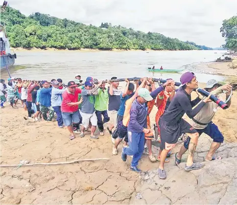  ??  ?? Longhouse residents helping to pull an underwater cable the ‘gotong royong’ way at Nanga Dia.