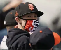  ?? JAE C. HONG - THE ASSOCIATED PRESS ?? A young baseball fan wears a face mask while watching a spring baseball game between the San Francisco Giants and the Los Angeles Angels in Scottsdale, Ariz., Sunday, Feb. 28, 2021.