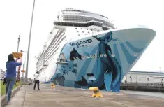  ??  ?? A woman takes pictures as Norwegian Bliss, the largest cruise ship to transit the expanded Panama Canal through Cocoli locks, passes through the Canal on the outskirts of Panama City, Panama. – Reuters photo