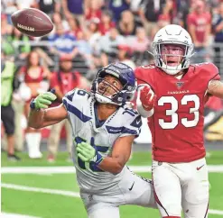  ??  ?? Cardinals cornerback Byron Murphy (33) breaks up a pass intended for Seahawks receiver Tyler Lockett during the second half at State Farm Stadium on Sept. 29 in Glendale.
