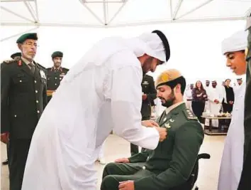  ?? WAM ?? Shaikh Mohammad decorates Shaikh Zayed Bin Hamdan Bin Zayed Al Nahyan with a Medal of Bravery for his service in Yemen during a Sea Palace ceremony yesterday. Shaikh Rashid Bin Hamdan Bin Zayed Al Nahyan (right) and Lt General Hamad Thani Al Rumaith...