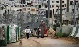  ?? Photograph: Dan Balilty/AP ?? A Palestinia­n woman and her children walk through an Israeli military checkpoint in the West Bank in 2008.