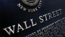  ?? MARK LENNIHAN — THE ASSOCIATED PRESS FILE ?? An historic marker on Wall Street in New York in shown. On Thursday global stocks were subdued as investors assessed the scant details of President Donald Trump’s U.S. tax overhaul.