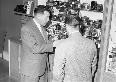  ?? ?? Circa 1963 - Owner and father of current owner Geoff, here we can see Victor Mathews with employee Clive Castle at one of the display cabinets