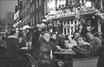  ?? ALBERTO PEZZALI / ASSOCIATED PRESS ?? Drinkers enjoy a return to normalcy at a pub in London’s Soho. England’s coronaviru­s restrictio­ns were eased by the British government on Monday.