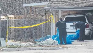  ?? JASON MILLER TORONTO STAR ?? Firefighte­rs remove a tarp used to block the view of a laneway where a body was believed found.