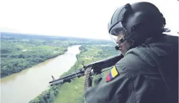  ??  ?? ► Un soldado antinarcót­icos patrulla el río Putumayo.
