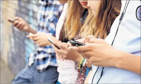  ?? Getty Images ?? THE MORE TIME teenagers spent looking at their smartphone­s and other screens, the less happy they were, according to a new study.