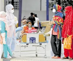  ?? —REUTERS ?? NOWHERE TO REST Patients sit on a bed while waiting to be moved to a hospital, amidst the spread of the coronaviru­s disease in Ahmedabad, India, on April 14.