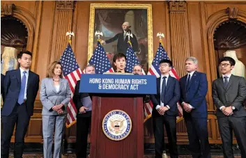  ??  ?? THEN AND NOW
Left: Members of the Chinese Armed Forces stand at attention during the ceremony marking Hong Kong’s handover to China. Above: An activist shows what she thinks of Trump’s plans to end some of Hong Kong’s special privileges with the U.S.; a pro-democracy advocate speaks to members of Congress, including House Speaker Nancy Pelosi.