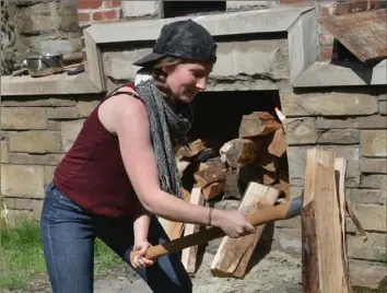  ?? Post-Gazette ?? In 2014, Shauna Kearns, then a student in Chatham University’s food studies program, chops wood at the Braddock Community Oven, one of the sites on the Office of Public Art walking tours this winter and spring.