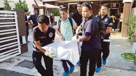  ?? [FOTO OMAR OSMAN/BH] ?? Anggota polis mengangkat mayat di sebuah rumah di Aman Jaya, semalam.