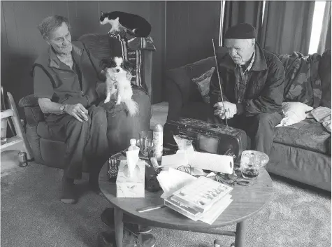  ?? TROY FLEECE ?? George Moffatt, left, with his dog Kricket and his neighbour Don Kezama in the Glen Elm Trailer Park, has had his faith restored.
