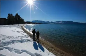  ?? The Associated Press ?? Sunlight shimmers off snow and water at Lake Tahoe in South Lake Tahoe, Calif.