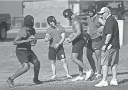  ?? MICHAEL CHOW/THE REPUBLIC ?? Chandler High football head coach Rick Garretson watches his quarterbac­ks perform a drill during practice May 10, 2021.