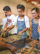  ??  ?? Josephine Manalo checks the making of peanut brittle at JMMPanutsa­han.