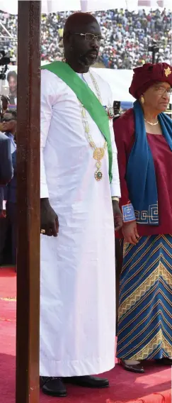  ?? — AFP ?? Liberia’s President- elect and former football star George Weah ( left) stands by former President Ellen Johnson Sirleaf after he was sworn- in on Monday in Monrovia.