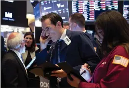  ?? CRAIG RUTTLE — THE ASSOCIATED PRESS ?? Trader Gregory Rowe and others work on the floor of the New York Stock Exchange.