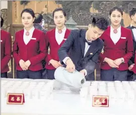  ?? Fred Dufour
AFP/ Getty I mages ?? A WAITER pours hot water at the opening session of the Chinese People’s Political Consultati­ve Conference at the Great Hall of the People in Beijing this month.