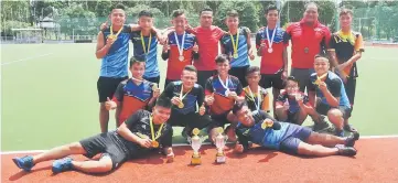  ??  ?? Excalibur HC players celebrate with coach Norden Tikot (second, right) and Celestine Michael (fifth, right) after winning the U16 and placing second in the U14 boys draw of the indoor rules tournament at the Sarawak Hockey Stadium last Sunday.