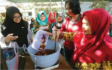  ?? GUSLAN GUMILANG/JAWA POS ?? EDUKASI: Riri (kiri) mengajari ibu-ibu kader toga Puskesmas Dukuh Kupang membuat ramuan herbal kemarin.