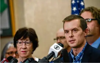  ?? ANDREW CULLEN/THE NEW YORK TIMES ?? Senator Susan Collins, Republican of Maine, left, listened as Representa­tive Jared Golden, Democrat of Maine, spoke during a press conference Oct. 26 in the aftermath of the mass shootings in Lewiston.