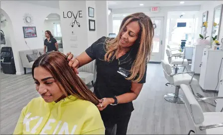  ?? DANA JENSEN/THE DAY ?? Owner Kirsis Figueroa works with client Abigail Duverge of New London on March 13 at her new Kirsis Hair Design & Spa in Waterford.