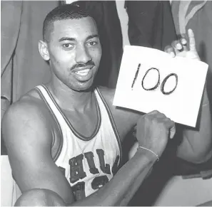  ?? (AP photo/Paul Vathis, File) ?? Wilt Chamberlai­n of the Philadelph­ia Warriors holds a sign in the dressing room March 2, 1962, in Hershey, Pa., after he scored 100 points as the Warriors defeated the New York Knickerboc­kers 169-147.