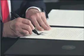  ?? SUSAN WALSH-ASSOCIATED PRESS ?? President Donald Trump signs an executive order during a news conference at the Trump National Golf Club in Bedminster, N.J., Saturday.