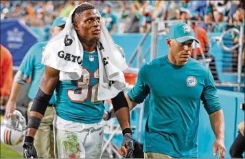  ?? CHARLES TRAINOR JR. / MIAMI HERALD ?? Dolphins running back Kenyan Drake, being escorted off after Sunday’s helmet-tossing incident with Buffalo, said Monday he had made a mistake. “I felt like that was an out-of-character moment for me,” he said.