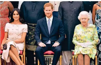  ?? FOTO: AP ?? Königin Elizabeth II. mit Harry und Meghan bei einer Feier im Buckingham-Palast im Juni 2018.