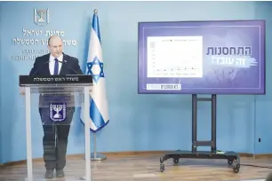  ?? (Abir Sultan/Reuters) ?? PRIME MINISTER Naftali Bennett addresses the media at the Prime Minister’s Office in Jerusalem last month in front of a display that reads: ‘Vaccinatio­n. It works!’