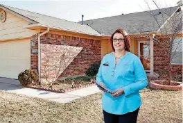  ??  ?? Kathy Fowler, 2018 president of the Oklahoma Associatio­n of Realtors, stands in front of a home she has listed at 9744 SW 27 for $154,990.