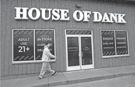  ?? MANDI WRIGHT/DETROIT FREE PRESS ?? House of Dank bud tender Raven Campbell, 32, puts up signs signaling House of Dank’s ability to sell recreation­al marijuana products in Detroit on Jan. 4. The city will begin accepting applicatio­ns for the second round of marijuana businesses Aug. 1.