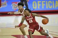  ?? MICHAEL WOODS — THE ASSOCIATED PRESS ?? Alabama guard John Petty Jr. drives past Arkansas’ Justin Smith in Fayettevil­le, Ark. on Feb. 24.