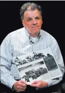  ?? DAVID BECKER/ LAS VEGAS REVIEW-JOURNAL ?? Las Vegas resident Tom Cameron displays a copy of a 1944 photograph of D-Day preparatio­ns that includes his father, Army Pvt. Allan Cameron.