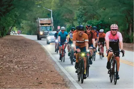  ?? MIKE STOCKER/SOUTH FLORIDA SUN SENTINEL ?? Cyclists ride on the roadway to gather early Saturday morning just south of Golfview Drive on A1A in Gulfstream to raise awareness for safer roads. They gathered at the site where a group of cyclists were struck by an SUV earlier in the week.